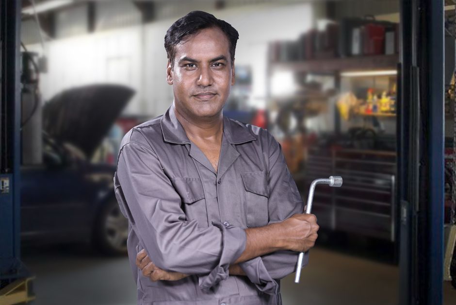Smiling auto mechanic ready for tire services