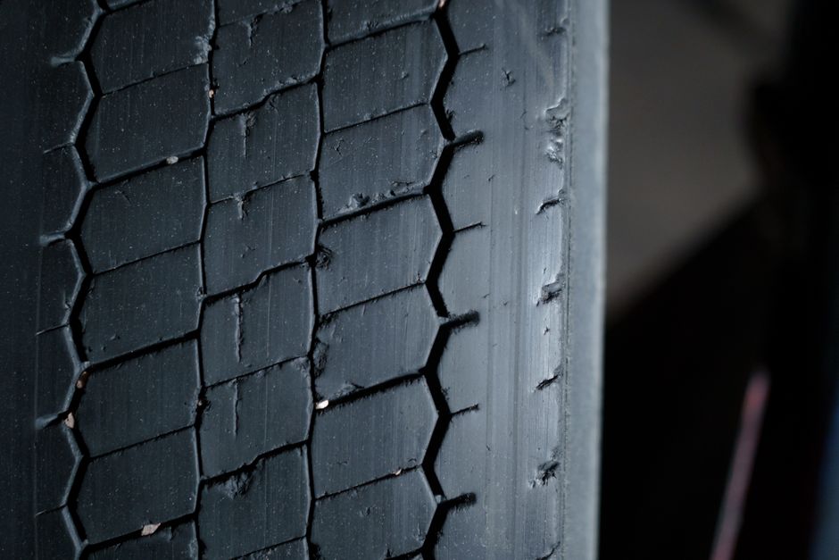 Technician checking tire tread and alignment
